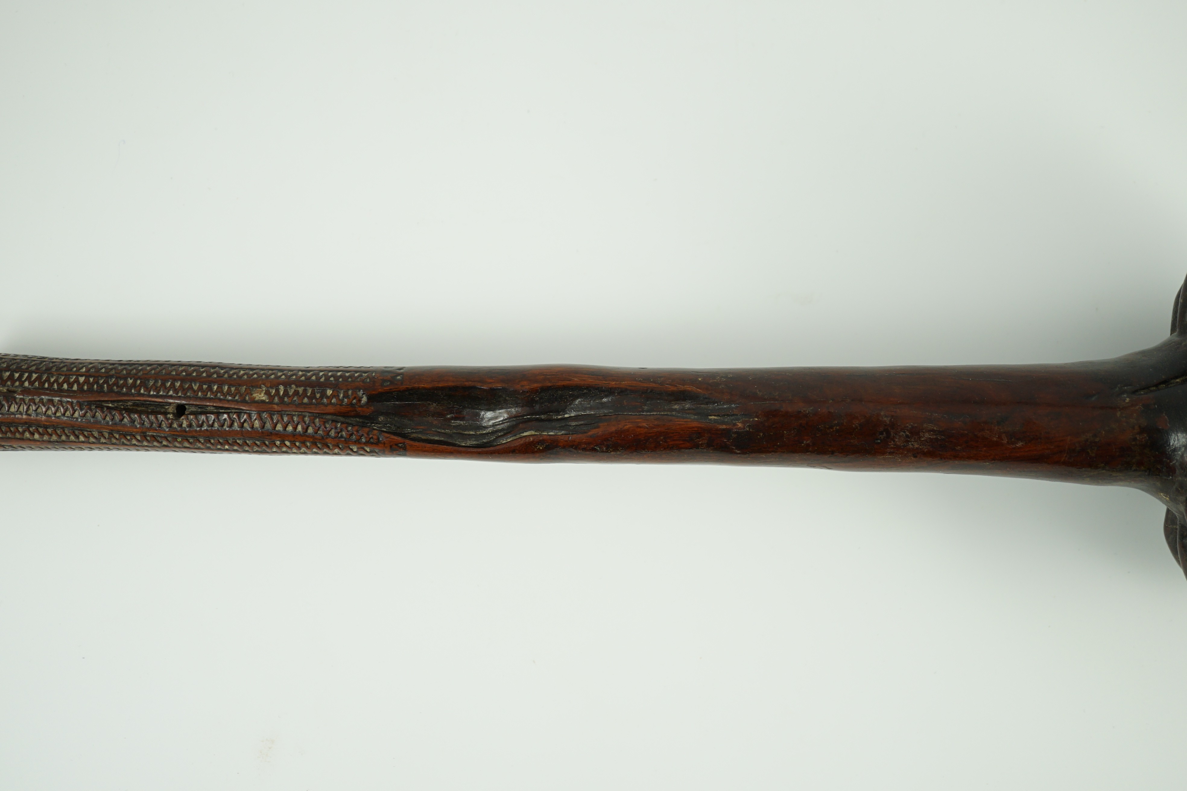 A Fijian hardwood throwing club, with zig-zag relief carved handle and further irregular spotted decoration, 40cm long